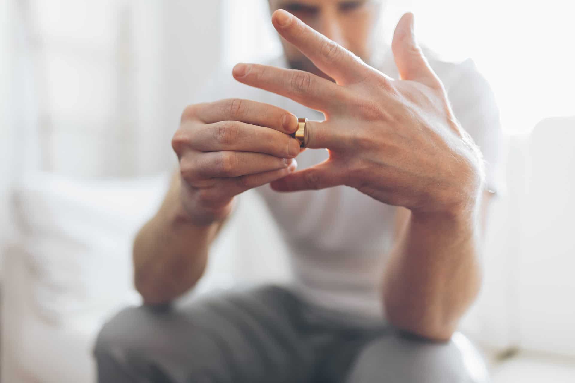 Heartbroken man holding a wedding ring