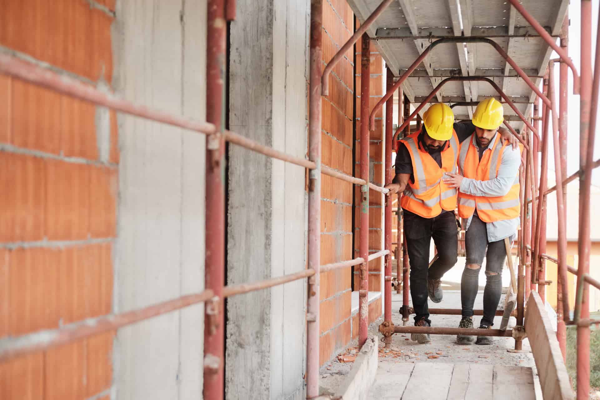 Construction worker helping injured colleague