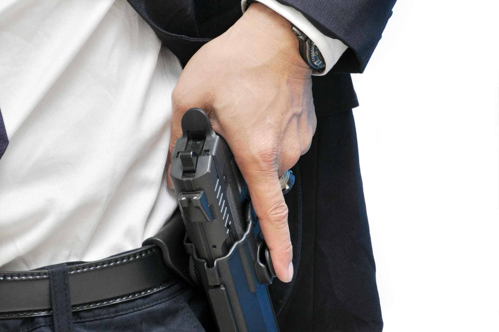 Armed bodyguard removing a gun from his holster