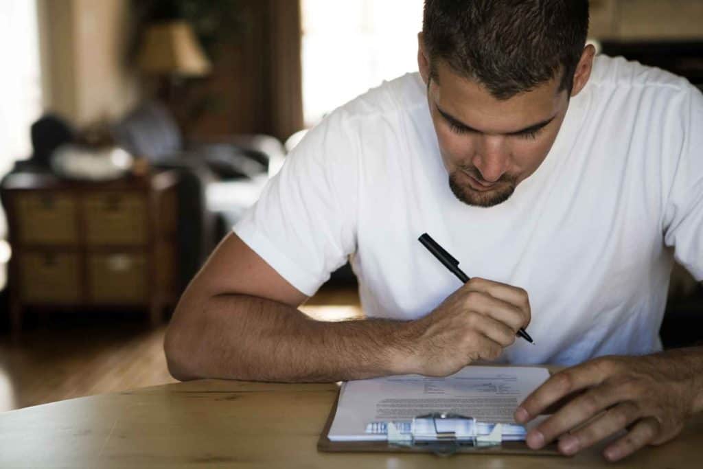 A man filling out NYC security guard application form